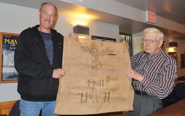 A simple burlap food bag emblazoned with the Nazi symbol makes its way to the Elmira Legion