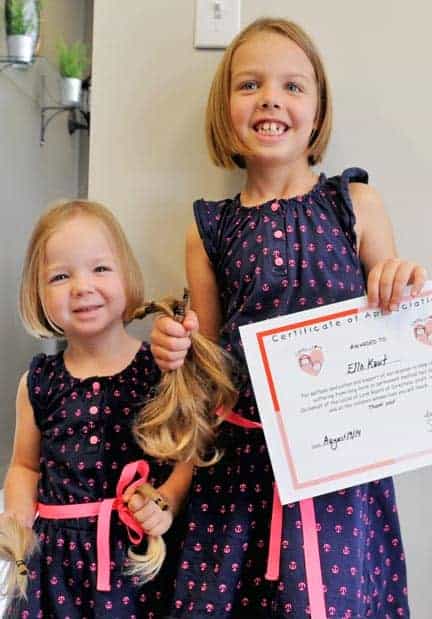 Madeline and Ella Kaut were feeling a bit unsure before chopping off eight inches of hair for Locks of Love, but were all smiles after it was done.[Whitney Neilson / The Observer]