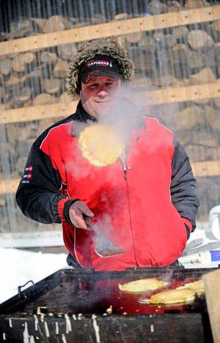 Local syrup producer Dale Martin flips a pancake at the ceremonial first tap event hosted by the Ontario Maple Syrup Producers’ Association and the Elmira Maple Syrup Festival at George Martin’s sugar bush just south of Heidelberg on Feb. 27. [Scott Barber / The Observer]