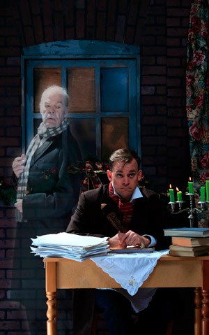 Gareth Potter, in the role of Charles Dickens, writes the classic book A Christmas Carol while Ebenezer Scrooge, played by Vince Carlin, looks over his shoulder