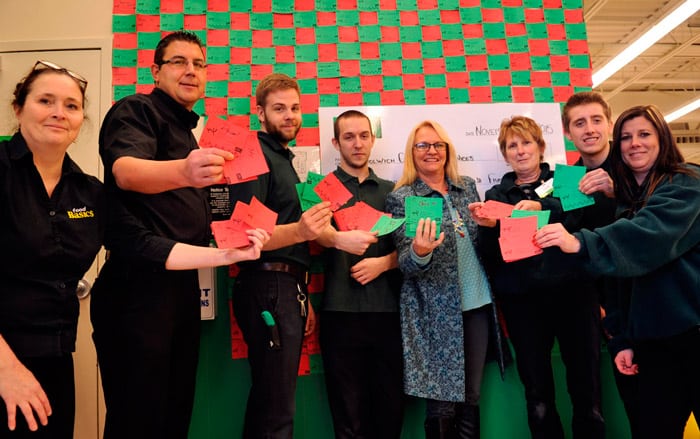 Kelly Christie from Woolwich Community Services (middle) and some staff from the Elmira Food Basics show off just some of the many donation cards filled out by customers giving $5 to the local food bank. The effort raised $4,905 for the local charitable organization