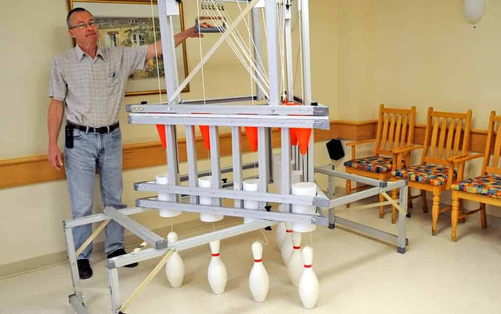 
                     With ingenuity and reused parts, handmade pinsetter brings bowling to Elmira retirement home
                     