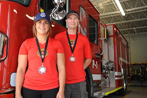 Wellesley volunteer firefighters Ryan Dosman and Madison Lavigne show off their medals from regional FireFit competitions. They are prepping for nationals in Calgary by competing at even more regional races.[Liz Bevan / The Observer]