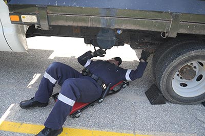 Staff Sgt. Michael Hinsperger double checks the brakes and the tires on a commercial vehicle pulled over during the commercial vehicle blitz in St. Clements on Wednesday morning. [Liz Bevan / The Observer]