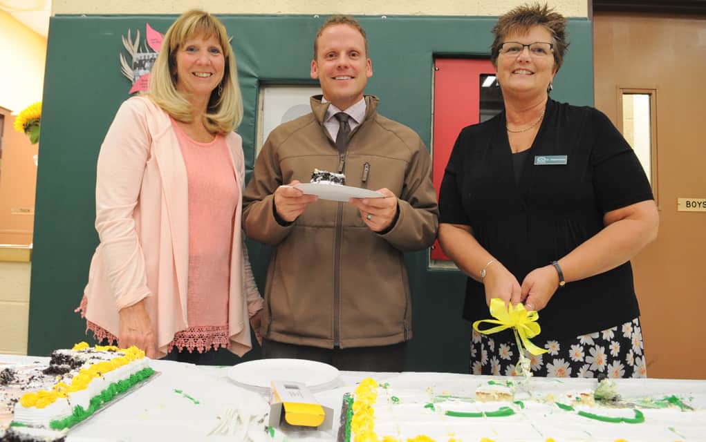 Secretary Liz Shantz, principal Shawn Thompson and EA Donna Dammeier serve cake to visitors. [Liz Bevan / The Observer]